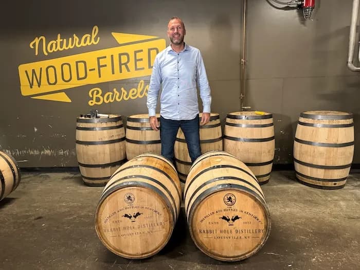 A barrel owner standing with his barrels at the distillery
